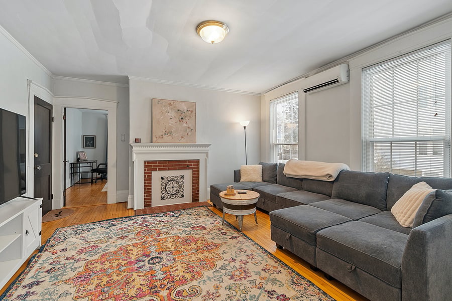 Spacious living room with floor-to-ceiling windows, a massive comfy couch, and large TV. Perfect for relaxing, watching movies, or enjoying natural light and stunning views.
