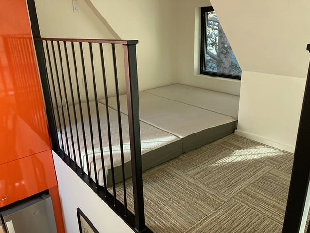 Sleeping loft above kitchen with folding queen mattress