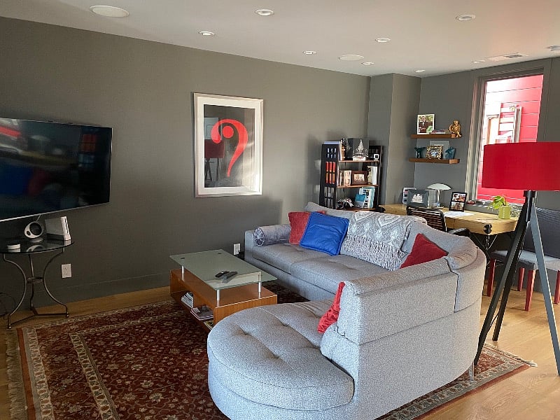 Cozy curved sofa with TV, next to fireplace. Desk behind sofa