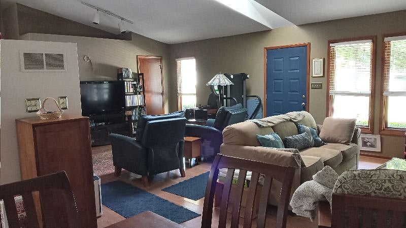 View into the extended living space with television, alexa, small desk