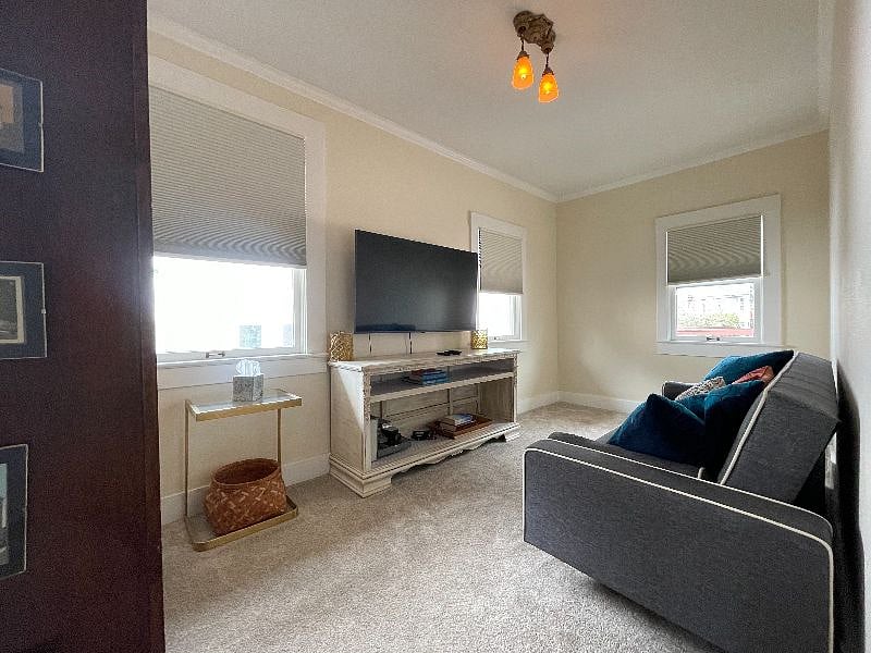 Daybed room off kitchen, with couch that folds into queen mattress, and TV that is visible while cooking