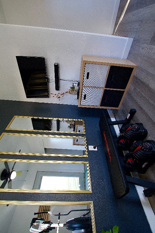 The fitness rooms contains a bench, adjustable dumbbells, a wall of mirrors, kettle bells, and an ab wheel.