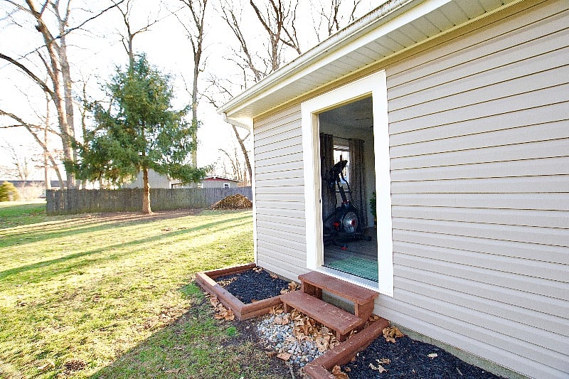 A view of the side and back yards.  You can see the exterior fitness room door from here.