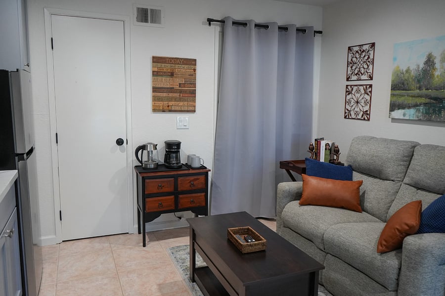 The living room has a comfy recliner loveseat and a lift top coffee table for eating or working on your laptop. End tables, lamp and great overhead lighting add to this cozy living space. 