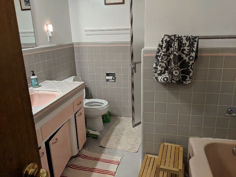 The common bathroom featuring a separate tub and shower. All original tile work.