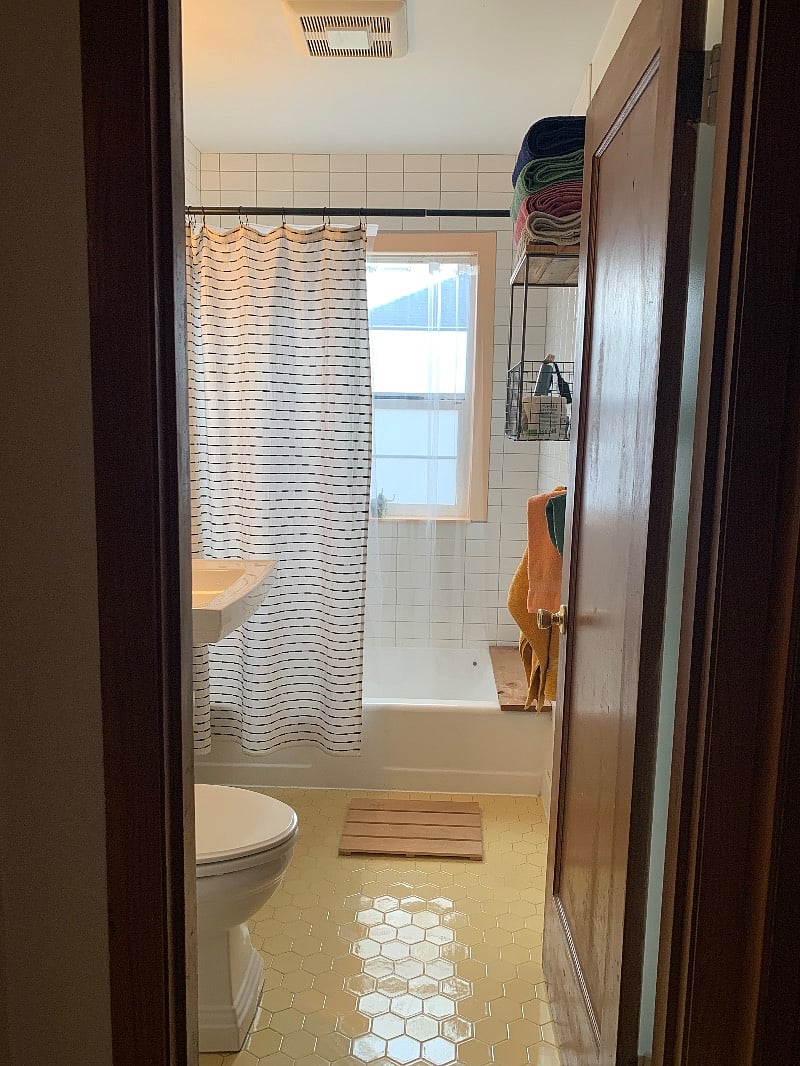 Original tile floor from 1947 and pops of color offset the updated white subway tile. Relax in the bath after a long day at work. The bathroom fan keeps towels crisp.