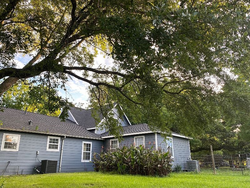 The side view of the house with the massive oak tree that shades your own deck!