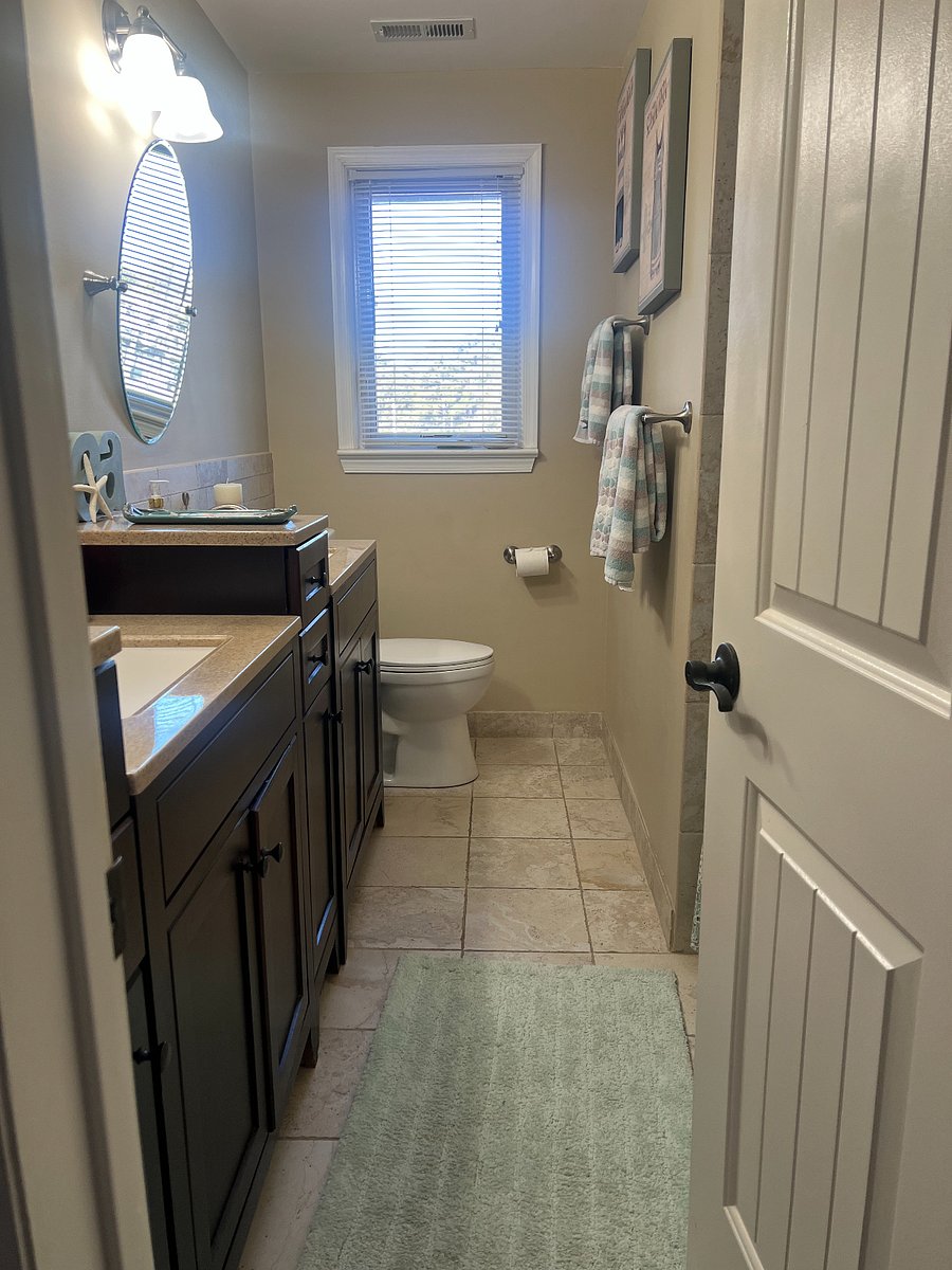 Hall bathroom with double vanity and tub