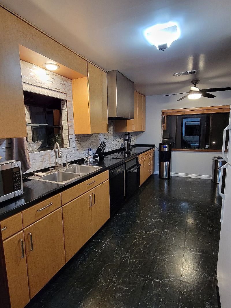 Kitchen with a backyard sliding door, microwave, coffee maker, filtered water, water dispenser hot and cold