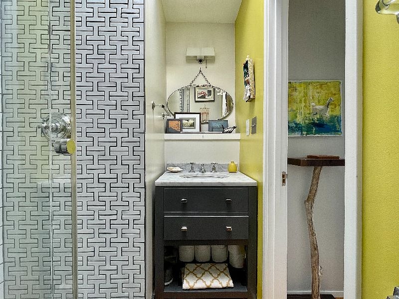 En suite full bathroom features a large walk in shower and skylight.