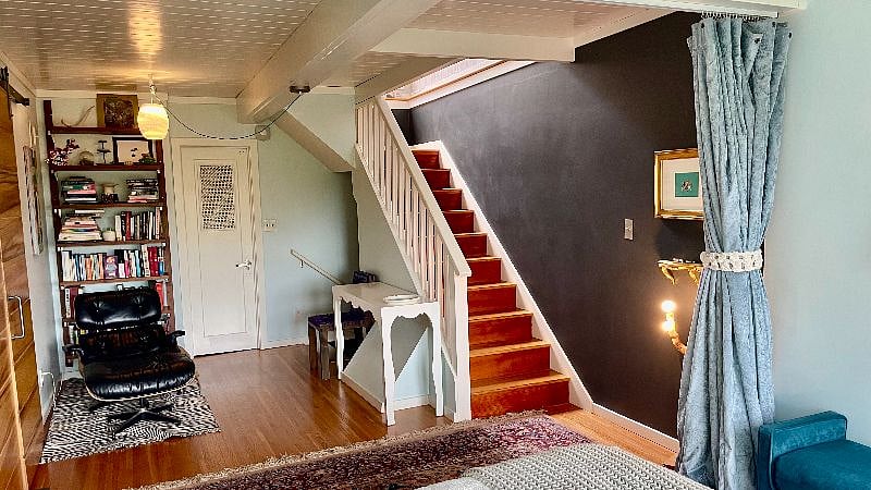 View of a reading nook and stairs to the top floor from the main bedroom.