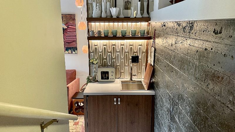 The bottom floor features a kitchenette with mini-fridge, sink and coffee maker.