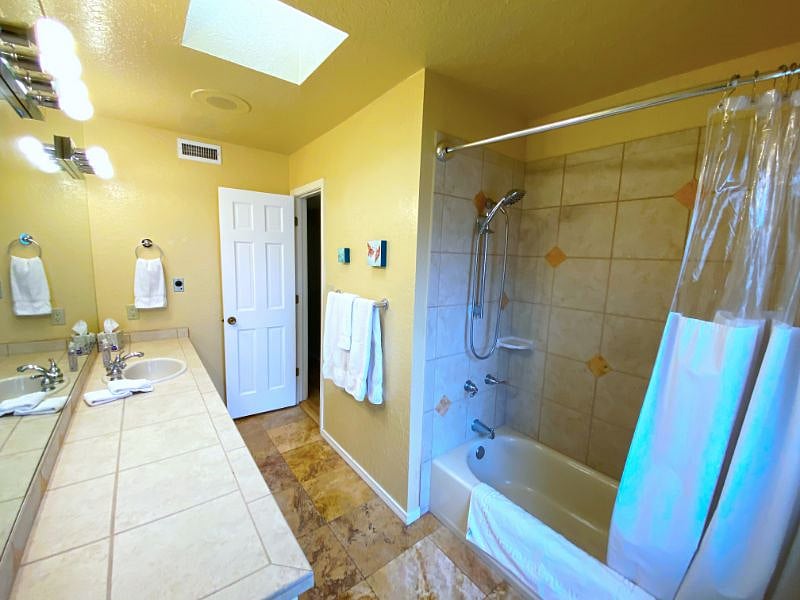 Hallway bathroom with tub and shower