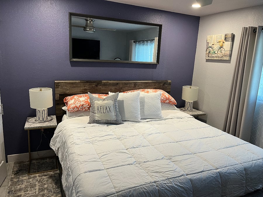 The second bedroom is equipped with a large single closet, nightstands, large above the bed mirror, ceiling fan, a study space, and a smart TV.