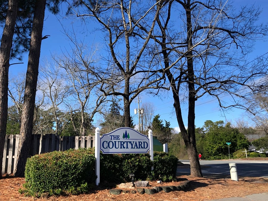 The private apartment is in a charming light blue three-story complex with white trim and a gray roof. There are stairs leading to the front door and a small yard in front. There is free parking on site.