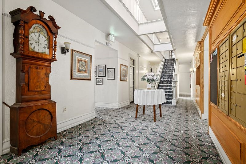 Very wide hallways. Our historic photo archive is on the left and our mailboxes are on the rights. Steps leading to unit 209. Notice also the grandfather clock!