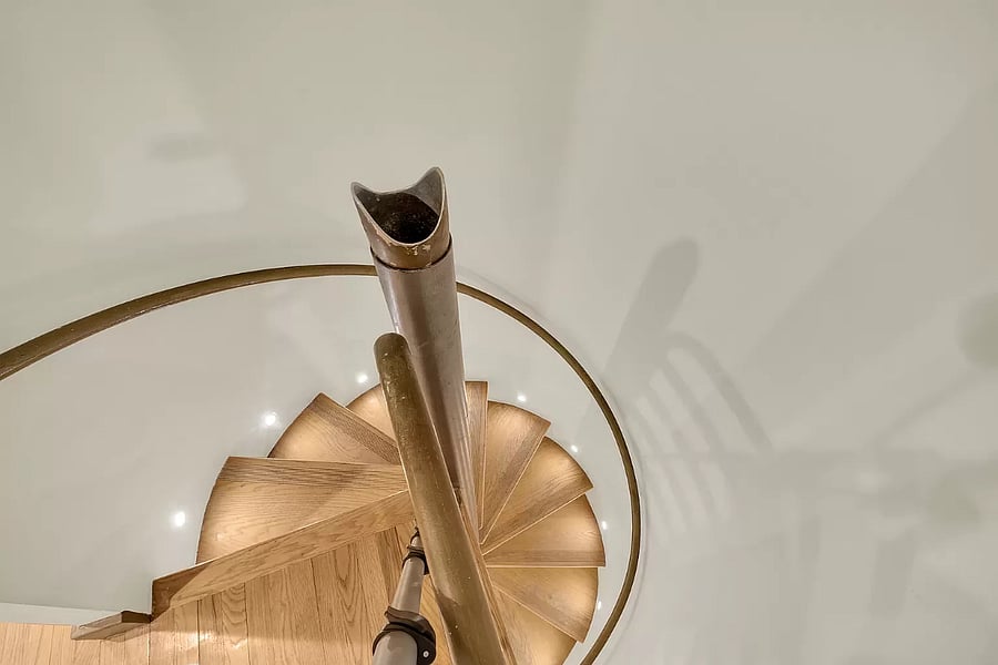 This two-level property offers an eye-catching spiral staircase connecting the floors. The sleek design provides a seamless flow between the living areas, creating a modern and chic atmosphere.