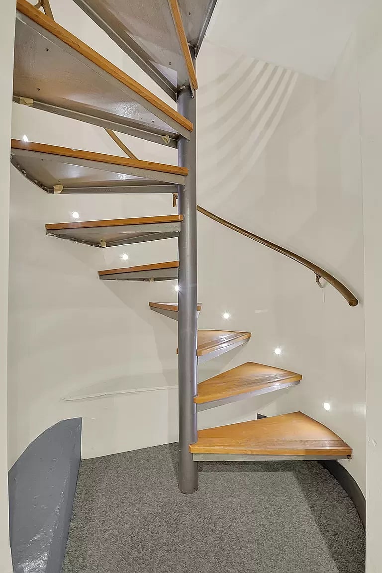 This unique two-story home features a beautiful spiral staircase, adding both elegance and charm. The staircase leads to the upper floor, creating a striking architectural element in this comfortable and stylish space.