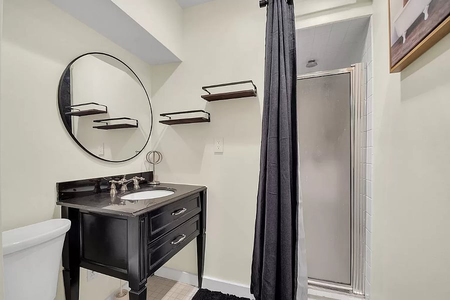 This full bathroom offers a sleek, modern shower and a stylish vanity. Its perfect for refreshing yourself after a long day, with plenty of counter space and a clean, bright design.