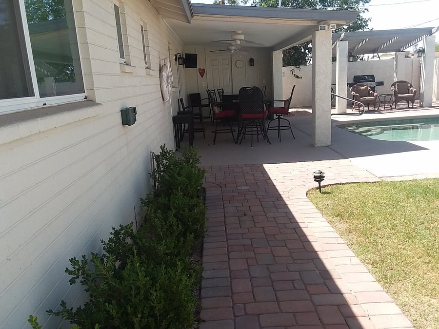 Pathway from house to a deck box full of pool toys.