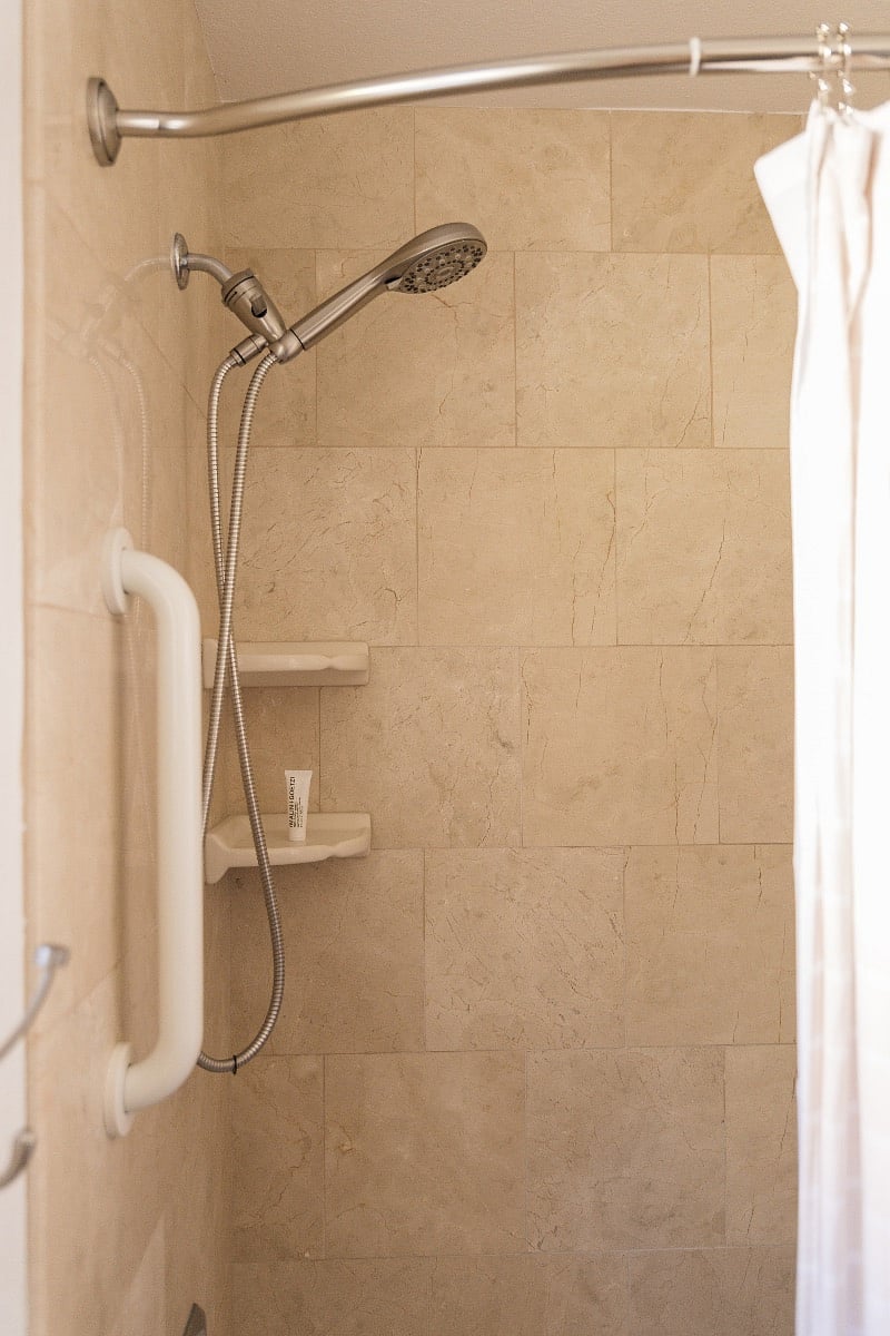 Shower boasts a curved shower curtain rod for added space.