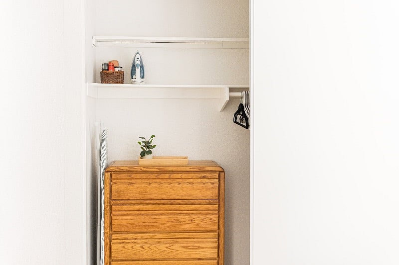 Master closet includes dresser and ironing supplies