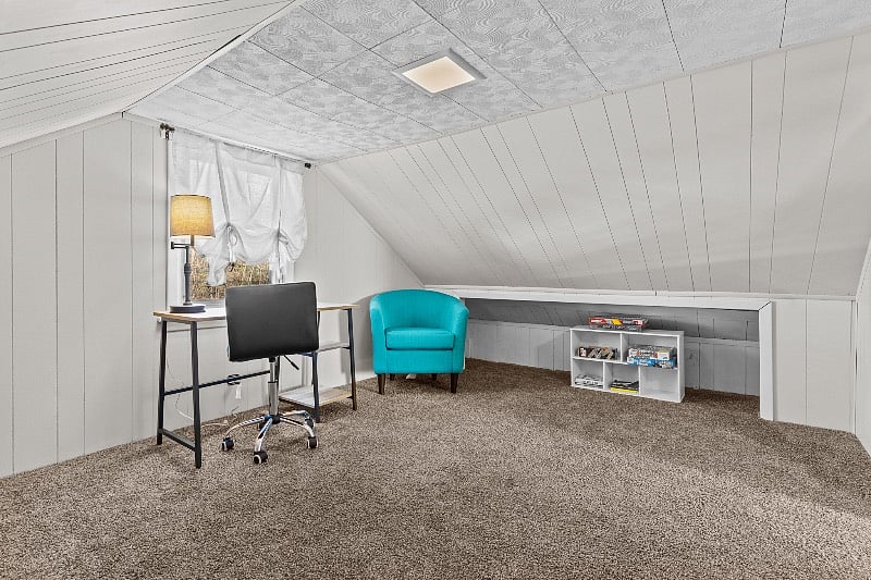 second floor space (lower ceiling height)  with work desk, books and garment rack for extra clothes storage 