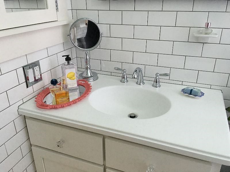 Bright light-filled Bathroom - 100 percent cotton towels, toilet paper, toiletries provided upon arrival for convenience, gleaming white subway tile, basketweave tile floor, porcelain tub with shower, Toto toilet, custom vanity with Corian counter and sink, large medicine cabinet, built-in Linen Closet, scale, hair dryer, magnifying mirror.