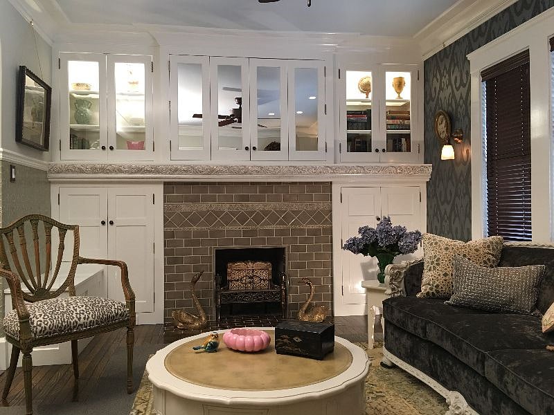 Hand-molded tiles surround fireplace. Custom cabinetry.  Folding, mirrored doors disguise 57" Smart TV when TV is not in use. Wall sconces are dimmable. Custom window treatments. 