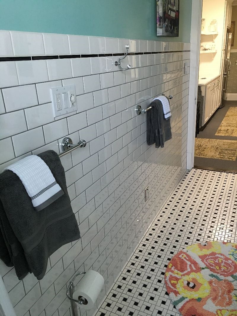 Bright light-filled Bathroom - 100 percent cotton towels, toilet paper, and toiletries provided upon arrival for convenience, gleaming white subway tile, basketweave tile floor, porcelain tub with shower, Toto toilet, custom vanity with Corian counter and sink, large medicine cabinet, built-in Linen Closet, scale, hair dryer, magnifying mirror.