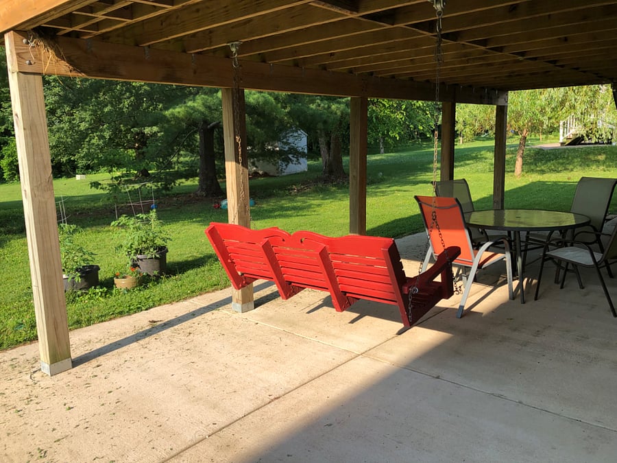 Covered patio with table, chairs and porch swing.