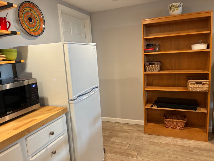 Shelf unit for extra kitchen storage space. The induction stove top is stored here.