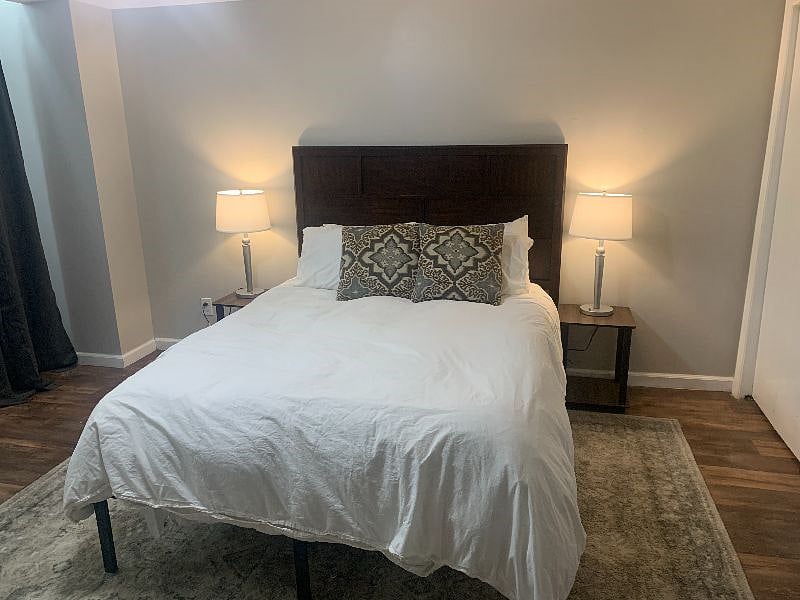 Large bedroom with queen-size bed, down comforter, and dual end tables & lamps. The mattress is a Nectar foam mattress, and gets lots of compliments from our tenants!