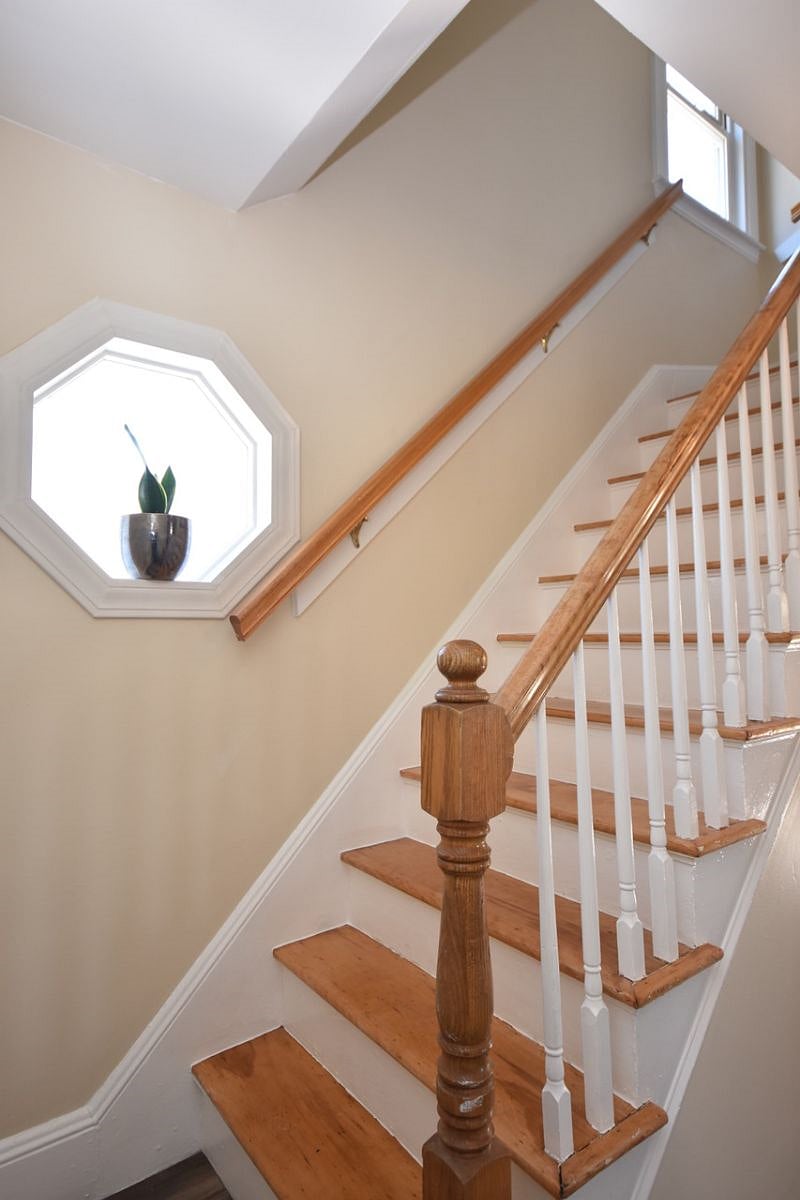 Stairs to bedrooms and bath with a decorative window