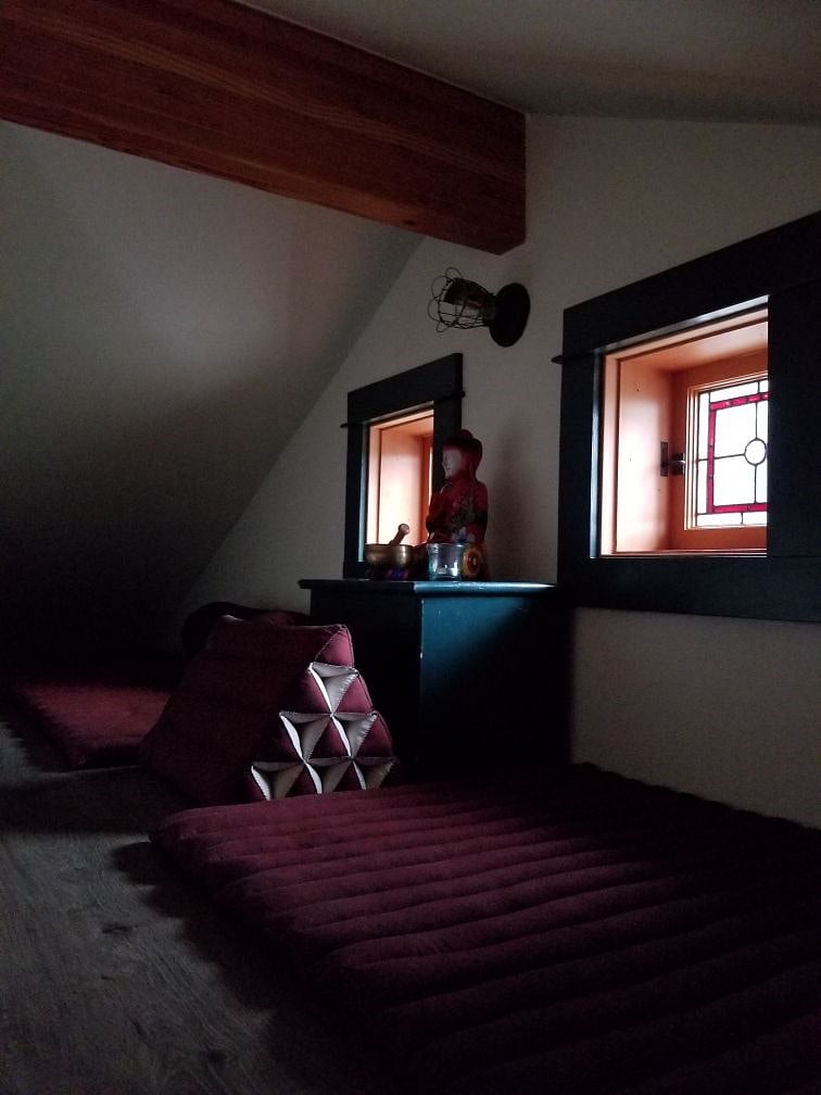 The meditation loft above the bedroom can be used as you like it; currently outfitted with two Thai massage mats, bolsters, neck rest, and small trunk for your yoga supplies, with singing bowl, candle, and floral Buddha buddy presiding.
