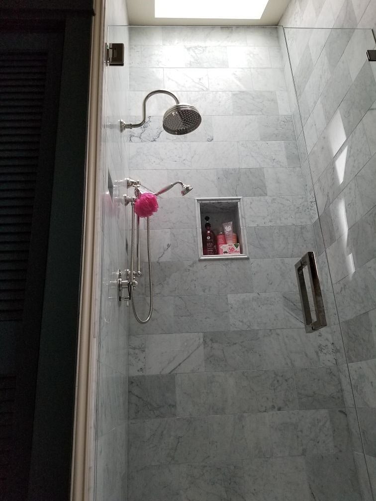 The spacious marble shower soars to 14' and is filled with soft light from the skylight above.