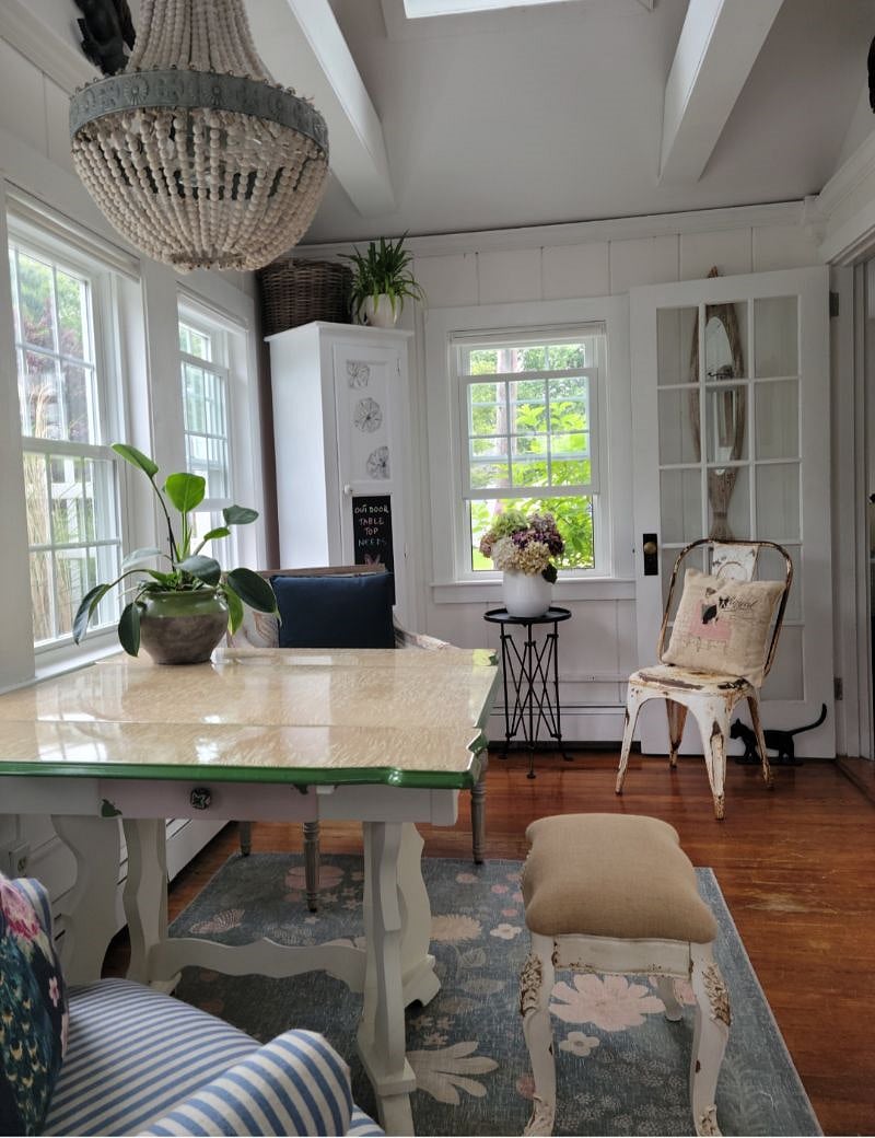 A cozy bright dining area with expandable retro table. Lots of extra chairs.