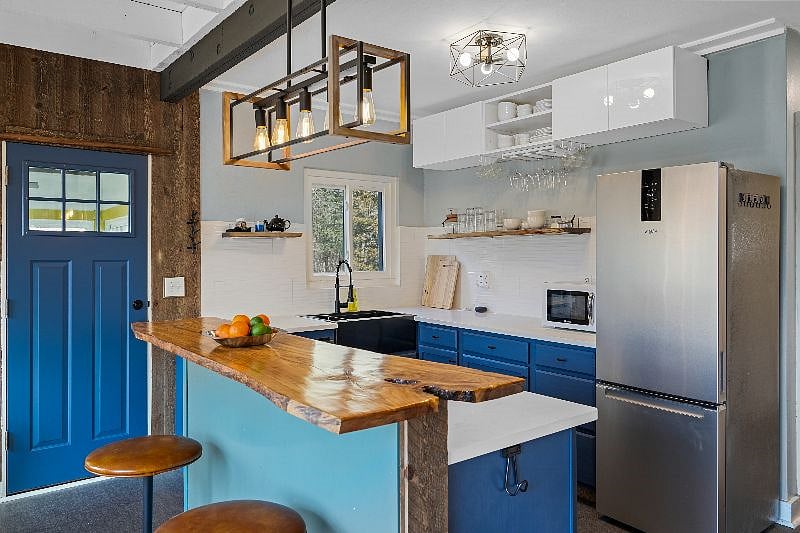 Open concept kitchen with live edge olive-wood bar top and lake views from the cozy breakfast table