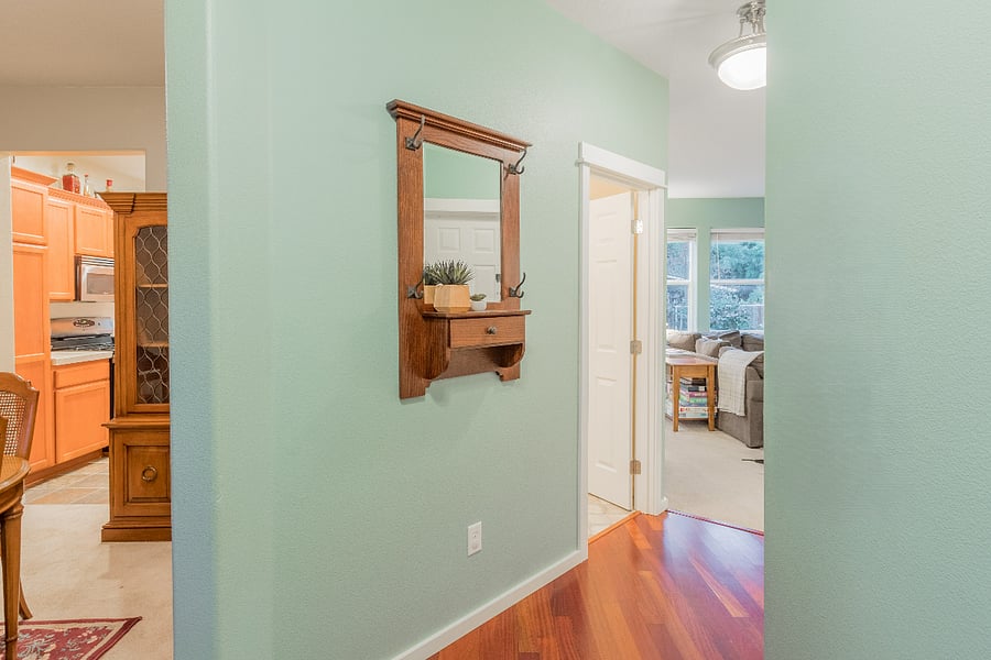 front entry with wood floors opens to dining room and kitchen (left), half bath, and great room (ahead on right)