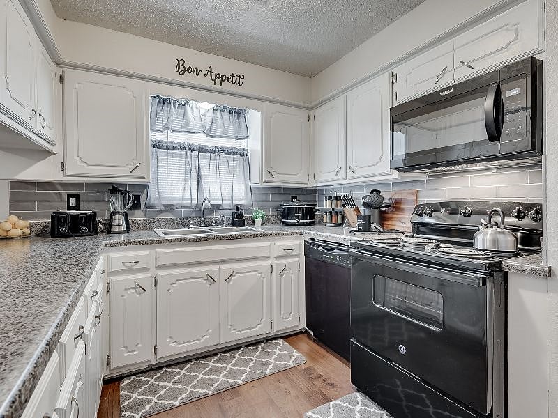 Kitchen with brand new appliances, cookware, dishes, flatware, crockpot, toaster, blender and spice rack.