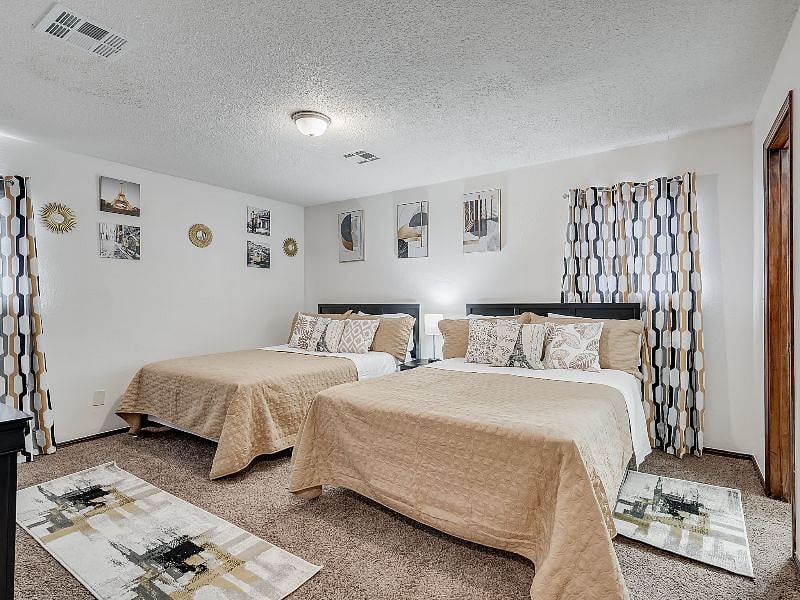 Master bedroom (2 queen size beds), dresser, walk-in closet with full bath, blackout blinds and smart TV.