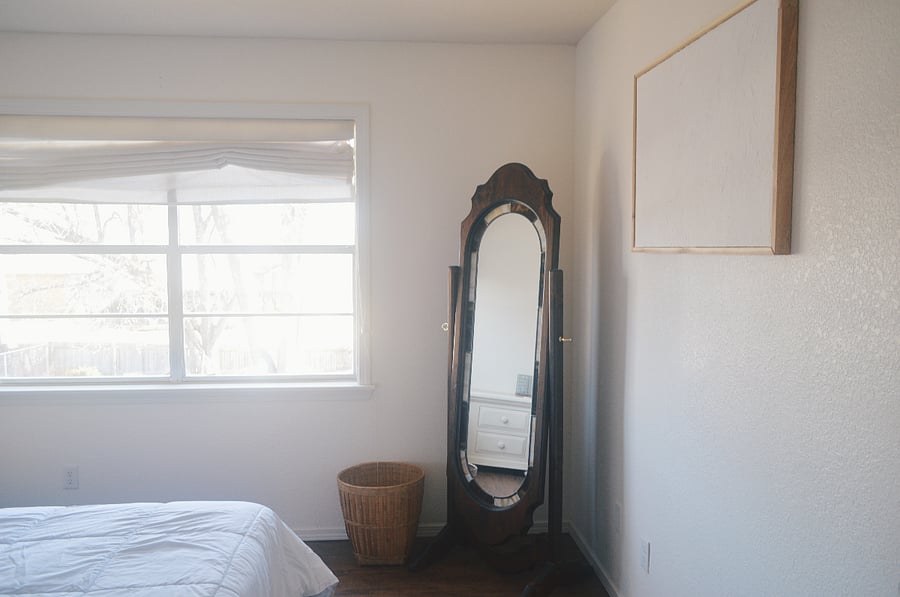 2. King bedroom with standing mirror and window facing the backyard
