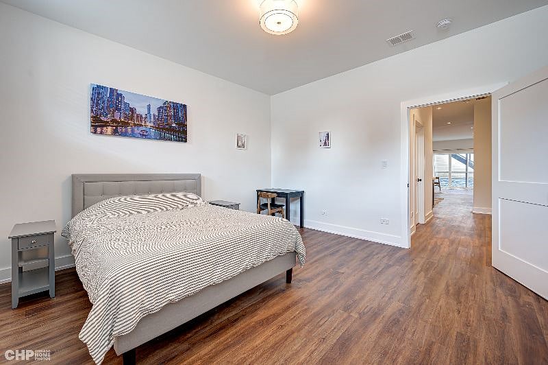 Large bedroom with queen bed. Desk and desk chair.