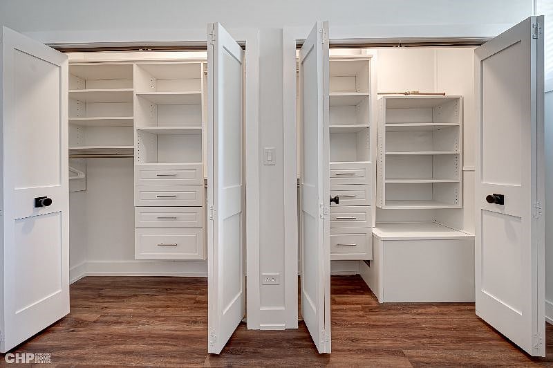 Large double closets with custom designed closet organizer shelving and drawers