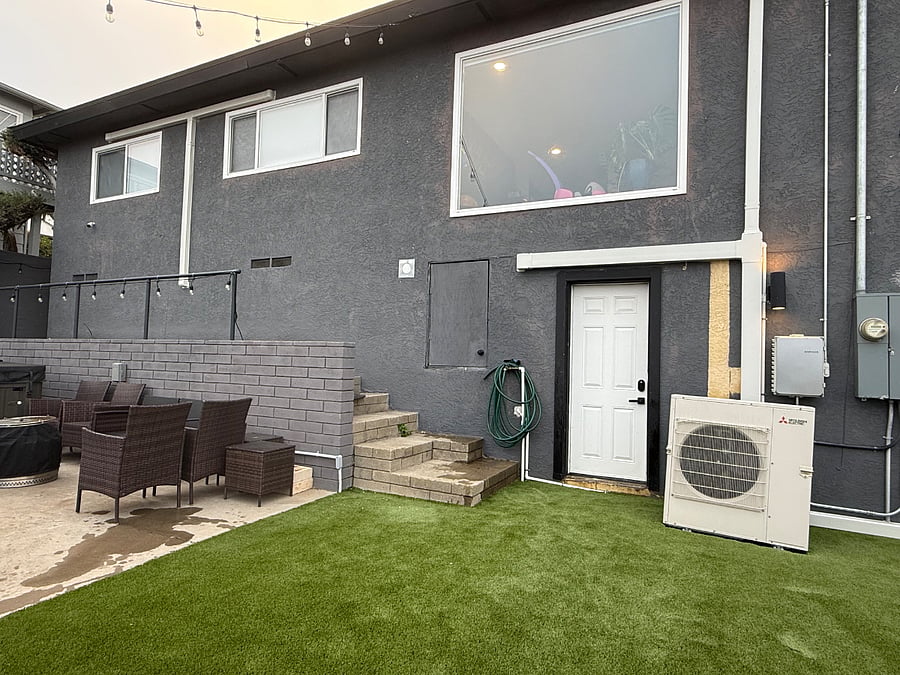 The white door is the studio entrance, the stairs to the left of the door lead to the front of the house.