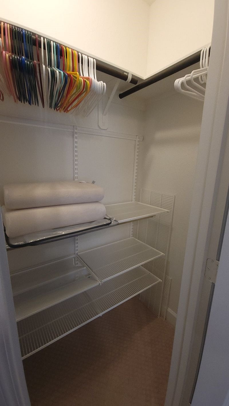 Bedroom closet with additional pillows and linens