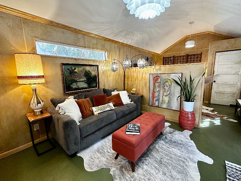 Lovely living space with comfy couch, fluffy pillows, oil paintings and indoor plants for fresh air.