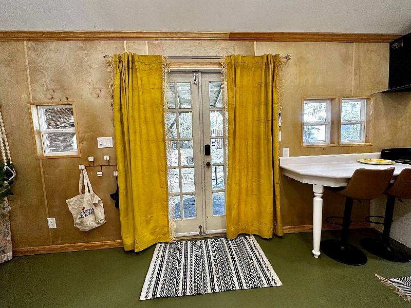 French Door with privacy curtains, to the right is the bar countertop for dining. And on the left are hooks for personal hanging. 