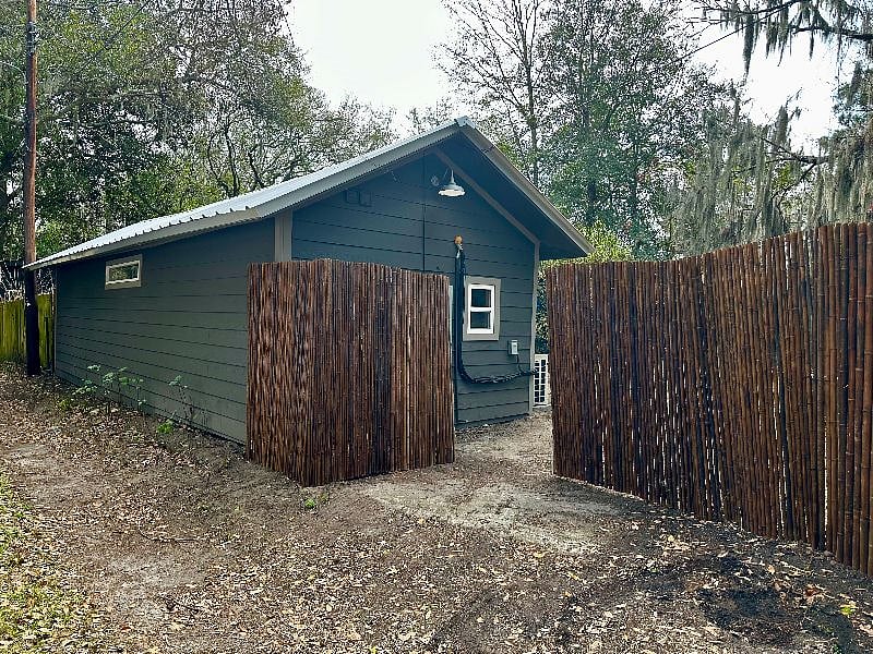 View of carriage house from the alley entrance. Gated with lock, Tesla Charger and outdoor light.