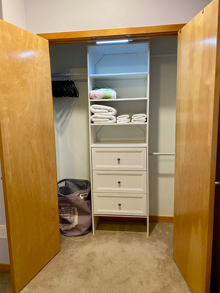 Guest Suite closet with provided linens, hangers, and laundry hamper.